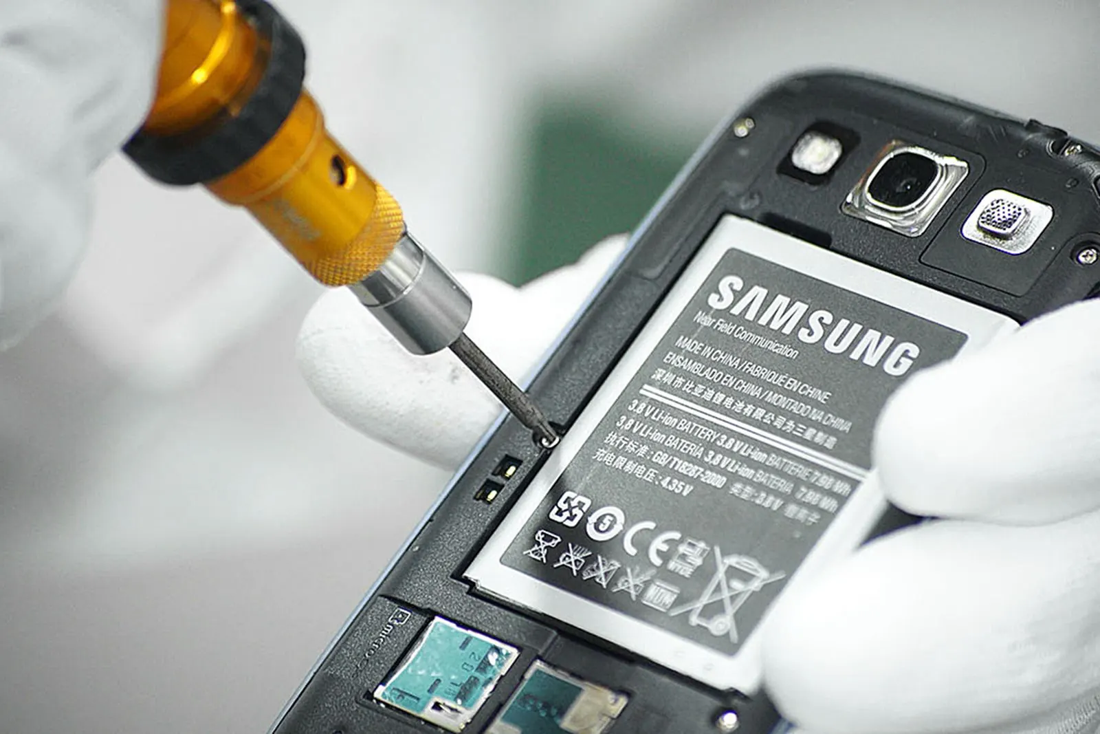 Dévissage du châssis d’un smartphone Samsung, batterie visible